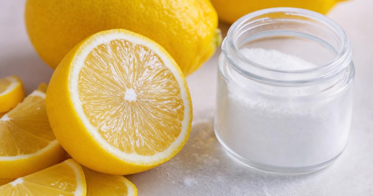 Citric acid crystals and sliced lemons: most commercial citric acid comes from mold fermentation, not citrus